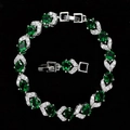 Detail of silver link bracelet with oval green emerald-cut stones and crystal halo - Green