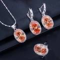 Detailed view of silver jewelry set with oval orange gemstones and beaded halo edges - Champagne