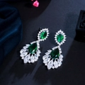Detailed view of teardrop emerald-cut earrings with marquise stones on velvet - Green