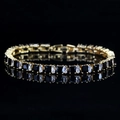 Primer plano de pulsera tenis bañada en oro con circonitas rectangulares negras y claras - Negro