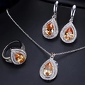 Macro shot of silver jewelry set with amber teardrop stones and zircon accents - Champagne