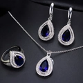 Detailopname van een sieradenset met peervormige blauwe zirkonia en zilveren plating - Saffierblauw / Maat 6