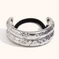 Silver hammered metal hair tie with irregular textured finish on minimalist beige background - Silver