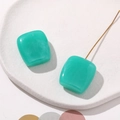 Detail view of mint green resin square earrings with a subtle marble texture and gold studs - Lake Green