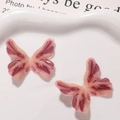 Makro-Detail von rosa Harz-Schmetterlingen mit Glitzer in einer weißen Keramikschale - Braun