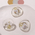 Detailed view of DIY resin bow charms with pearls, gold rings and sparkles on a tray - Pearl Diamond Style