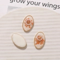 Detailed oval resin charms with orange dried flowers and pearls in gold alloy frames - White