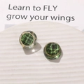 Detailed close-up of vintage resin earrings with green plaid pattern and gold frame - Green