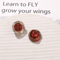 Detailed macro view of vintage red plaid resin charms with elegant gold metal frames - Red