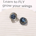 Macro detail of vintage resin earrings featuring blue tweed pattern and gold metal edges - Blue