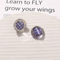 Detail of purple plaid resin earrings with gold metal edges on a ceramic display - Purple