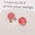 Close-up of vintage red fabric pattern earrings with resin coating and gold metal frame - Pink