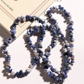 Macro view of natural irregular sodalite gemstone chips strung on a clear elastic cord - White Blue Dot Stone Chips
