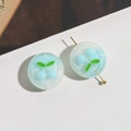 Close-up of translucent light blue resin beads with embossed cherry design and central drill hole - 1 Piece / Blue