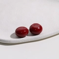 Close-up of deep red glossy resin round studs on a minimalist white ceramic tray - Dark Red