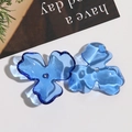 Macro detail of dark blue translucent acrylic flower charms with center hole for DIY earrings - L Blue