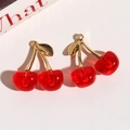 Macro detail of cherry pendants with translucent red resin and gold leaf hooks for DIY - Bright Red