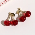 Close-up of translucent cherry pendants with gold leaves for DIY jewelry making - Dark Red