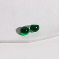 Macro shot of two dark green 10mm translucent resin half-round beads for DIY jewelry - Green