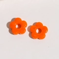 Macro shot of orange five-petal glass flower charms for DIY handmade jewelry crafts - Orange