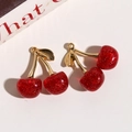 Detailed view of cherry pendants with red translucent resin and golden glitter finish - Glitter Finish