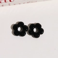 Macro detail of two black glazed resin flower beads with hollow center for DIY jewelry making - Black
