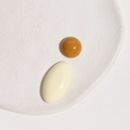 Flat lay of caramel round and beige oval resin cabochons on a white textured ceramic tray - Yellow Half Ball + White Oval