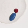 Macro shot of glossy Morandi red round and blue oval resin cabochons on a white tray - Red Half Ball + Blue Oval