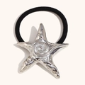 Coletero elástico negro con un dije de estrella de mar plateada y texturas naturales - Color Acero