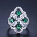 Detail van een bloemen cocktailring met smaragdgroene en witte zirkonia - Maat 6 / Groen