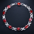Detail view of oval ruby-red stones and pavé set crystals on a silver-plated luxury bracelet - Red