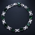 Detailed macro of silver bracelet with eight oval green stones and X-shaped crystal links - Green