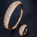 Detailopname van gouden sieradenset met sprankelende zirkonia op armband en de ring - Maat 7 / Goud