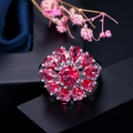 Primer plano de un anillo floral con circonitas rojo rubí y una banda de metal en tono plateado - Talla 6 / Rojo