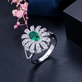 Detailopname van een bloemenring met ovale groene edelsteen en zirkonia-accenten - Maat 6 / Groen