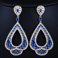 Vue détaillée des boucles d'oreilles gouttes en zircon bleu et monture dorée - Or Bleu