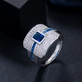Macro-opname van grote blauwe rechthoekige zirkoonring met witte kristallen op zilver metaal - Maat 6 / Blauw