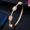 Detailed close-up of gold-plated bangle with geometric segments and paved AAA cubic zirconia - Bangle / Gold