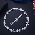 Detailed macro view of silver-tone chain bracelet with oval AAA cubic zirconia and fold-over clasp - White
