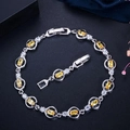 Silver bracelet with AAA yellow oval zircons and round white diamonds on dark background - Yellow