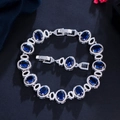 Silver-toned chain bracelet with oval sapphire blue stones and adjustable fold-over clasp - Blue