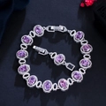 Detail shot of brass 18K gold plated bracelet with purple zircons on black texture - Purple