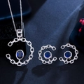 Detail van zilveren sieradenset met blauwe saffieren, diamant-halo en bloemdecoratie - Saffierblauw