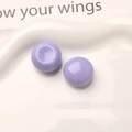 Close-up of glossy lavender resin round beads for DIY jewelry on a white wavy plate - Purple