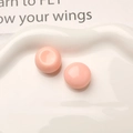 Detailed close-up of glossy pink resin dome cabochons on a white decorative ceramic tray - Pink