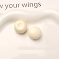 Macro view of cream white macaron resin cabochons on a wavy ceramic tray for DIY jewelry - White