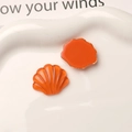 Macro view of orange resin shell charms for DIY shoes, showing both front and back textures - Orange