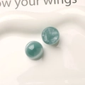 Macro shot of 16mm blue starry resin beads with cat-eye effect on white ceramic tray - Gray Blue