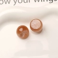 Macro shot of 16mm warm amber resin beads with cat-eye effect for DIY jewelry making - Brown