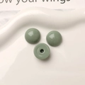 Gros plan de perles rondes en résine vert foncé brillantes pour bijoux DIY - Vert